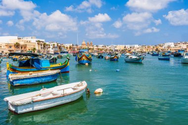 MARSAXLOKK, MALTA - SEPTEMBER 03, 2024: Geleneksel renkli balıkçı tekneleri, Malta 'nın küçük bir balıkçı kasabası olan Marsaxlokk limanına demirlemişti..
