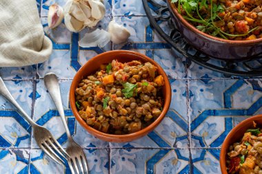 Kahverengi mercimek yahnisi, beyaz şarap, serrano jambonu ve füme paprika.