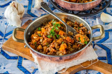 Kahverengi mercimek yahnisi, beyaz şarap, serrano jambonu ve füme paprika.