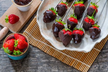Koyu çikolataya batırılmış taze çilekler.