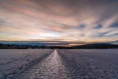 Finlandiya 'da Akaslompolo Gölü üzerinde gökkuşağı bulutu olarak bilinen nadide nadide bulutlarla güzel bir kış günbatımı..