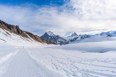 İsviçre 'nin Grindelwald kayak merkezindeki İsviçre Alpleri' nin ilk dağından görülen karla kaplı tepeleriyle kış manzarası