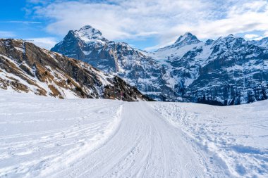 İsviçre 'nin Grindelwald kayak merkezindeki İsviçre Alpleri' nin ilk dağından görülen karla kaplı tepeleriyle kış manzarası