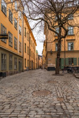 STOKHOLM, SVEDEN - 10 Mart 2025: Gamla stan (eski kasaba) kaldırımlı sokakları ve renkli 17. ve 18. yüzyıl binaları popüler bir turizm beldesi..