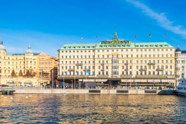 STOCKHOLM, SWEDEN - 08 Mart 2025: Stockholm 'ün merkezindeki Norrstrom' da Strandvagen seti üzerinde Grand Hotel. Strandvagen rıhtımda kafeler ve resimli teknelerle dolu.
