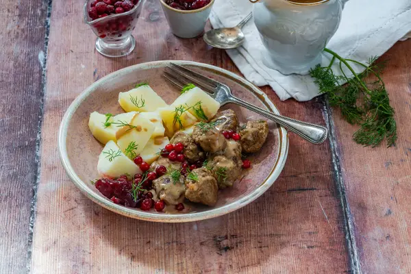 Kaynamış patates ve yaban mersinli geleneksel İsveç köftesi.