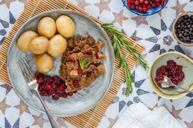 Geleneksel Norveç ren geyiği güveci, yaban mersini ve haşlanmış patates.