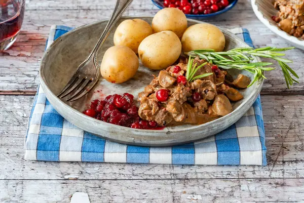 Geleneksel Norveç ren geyiği güveci, yaban mersini ve haşlanmış patates.