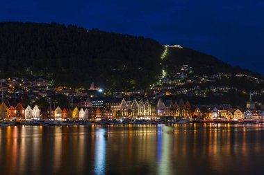 Alacakaranlıkta limanın karşısındaki ünlü Bergen Bryggen bölgesinin renkli binalarının manzarası.