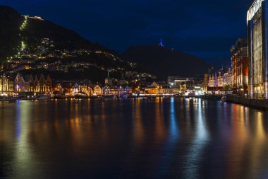 Alacakaranlıkta limanın karşısındaki ünlü Bergen Bryggen bölgesinin renkli binalarının manzarası.