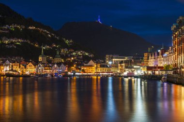 BERGEN, NORway - 16 Ağustos 2025: alacakaranlıkta Bergen 'in limanını görün. Bergen Norveç 'in en büyük ikinci kentidir ve uluslararası bir su ürünleri, denizcilik, off-shore petrol endüstrisi merkezidir..