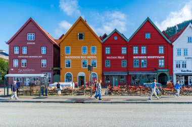 BERGEN, NORway - 17 AĞUSTOS 2025: Bergen 'deki ünlü Bryggen' in doğu tarafında sıralanan ticari binalar. Bryggen, 1979 yılından beri UNESCO 'nun Dünya Kültür Mirasları listesinde yer alıyor.