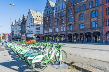 BERGEN, NORWay - 17 AĞUSTOS 2025: Bergen 'in tarihi şehir merkezi Bryggen' da yeşil şehir kiralama e-motorlarından oluşan bir filo hizaya geldi. Kiralık bisikletler şehirde alternatif ulaşım araçları sunuyor.