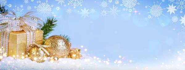 Christmas golden decoration and gift isolated on blue blur background.