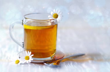 Papatya çayı ve papatya çiçekleri şeffaf cam bir kupa..