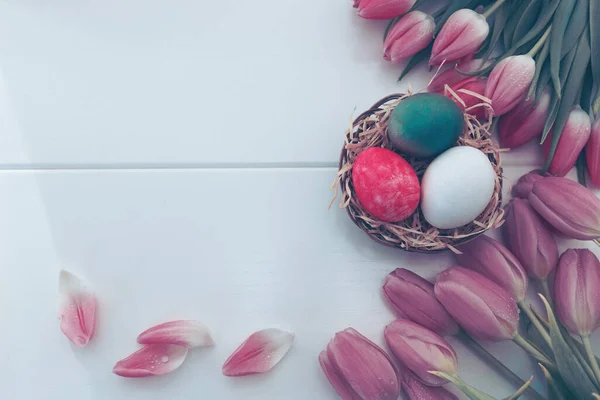 イースターエッグとピンクチューリップ 白い背景にお祭りの装飾 春のグリーティングカード — ストック写真