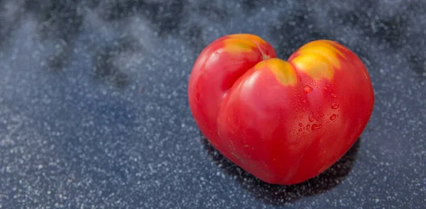 灰色の背景に心の形をした赤いトマト — ストック写真