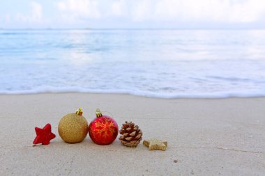 Mutlu noel baloları ve beyaz Karayip kumları üzerindeki süslemeler.