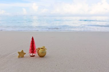 Mutlu noel baloları ve beyaz Karayip kumları üzerindeki süslemeler.