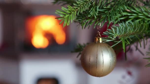 Χριστουγεννιάτικο Δέντρο Υποκατάστημα Χρυσή Μπάλα Και Θαμπάδα Καύση Τζάκι Φόντο — Αρχείο Βίντεο