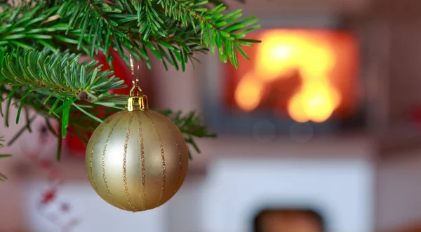 Ramo Dell Albero Natale Con Palla Oro Sfocatura Bruciante Camino — Foto Stock