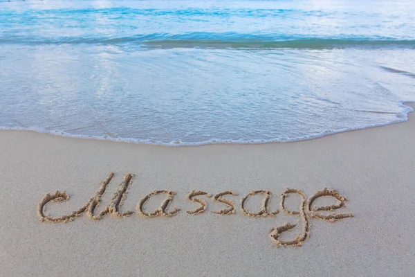 ビーチの砂に書かれた言葉のマッサージ ビーチと波の背景 — ストック写真
