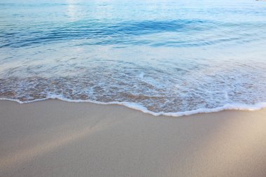 Karayip kumlu sahilinde yumuşak mavi okyanus dalgası.
