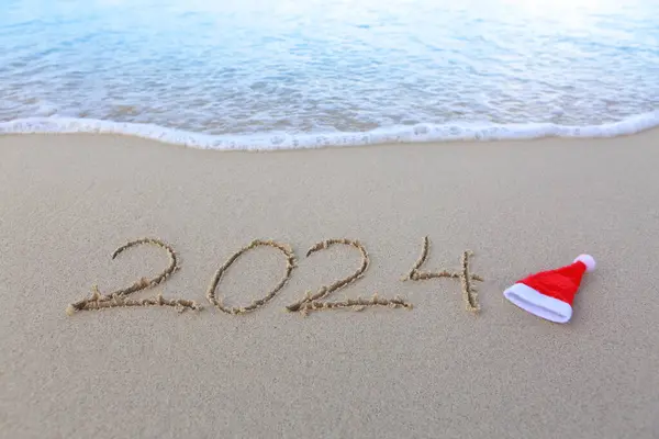 Happy New Year 2024 text on the sea beach.