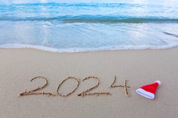 Happy New Year 2024 text on the sea beach.