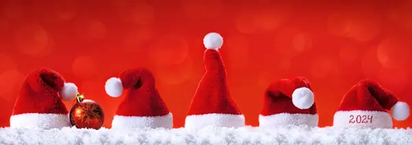 Санта Шляпы Белом Снегу Изолированы Красном Фоне Новым 2024 Годом — стоковое фото