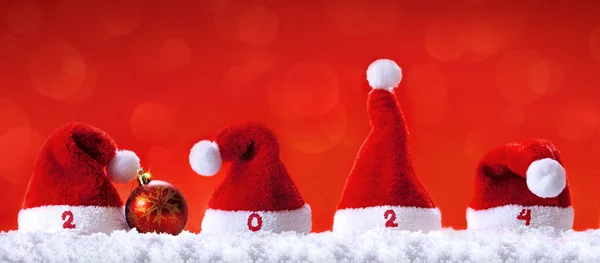 Chapéus Papai Noel Neve Branca Isolada Fundo Vermelho Feliz Ano — Fotografia de Stock
