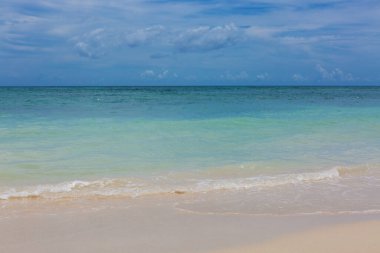 Karayip kumlu sahilinde yumuşak mavi okyanus dalgası.