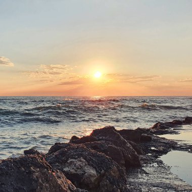 Günbatımı gökyüzü ve güneşli deniz. Suyun üzerinde ufuk..