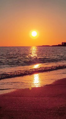 Deniz dalgaları üzerinde renkli bir gün batımı. Denizin üzerinde gün batımı..