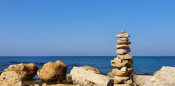 碧海背景下阳光灿烂的海滩上的金字塔石 — 图库照片