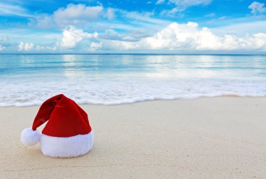 Mutlu Noeller Noel Baba şapkası beyaz Karayip kumlarında.