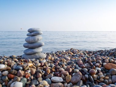 Deniz taşları piramidi, deniz tarafından oluşturulmuş. Nesne odaklı, arkaplan bulanık.