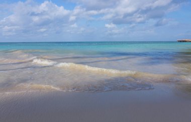 Karayip kumlu sahilinde yumuşak bir mavi okyanus dalgası. Seyahat arkaplanı kavramı.
