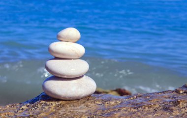 Piramit kaplıca taşları mavi deniz arka planında güneşli bir günde.