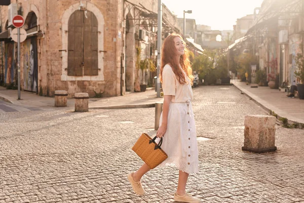 ヨーロッパの街をポーズをとってレトロなバッグを持って笑っている流行の女の子の完全な長さのビュー 夏のストリートファッションのコンセプト — ストック写真