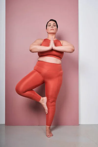 体の垂直ビュー正の女性トレーニングヨガ 瞑想で接続された手スタジオショットオンピンクの背景 — ストック写真