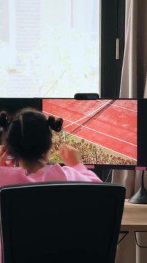 Esmer kızın evden çalışırken ya da ders çalışırken bilgisayar ekranına baktığı dikey görünüm