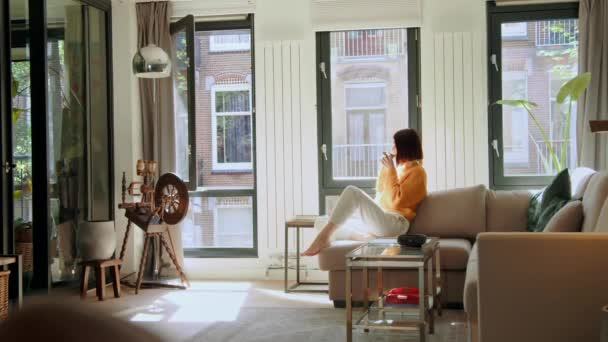 여자가 뜨거운 창가에 아파트에 마시기 개념에 사람들 — 비디오