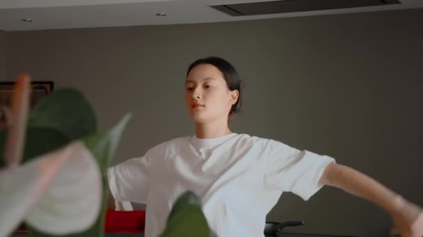 健康なアジアの女性は踊りの前に暖まる ブルネット女の子練習一人でザ居心地の良いキッチンに自宅 — ストック動画