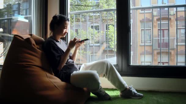 Yastıkların Başında Oturan Mutlu Kadının Akıllı Telefon Kullanışının Tam Boy — Stok video