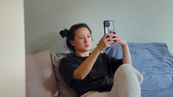 Азиатская Целеустремленная Женщина Использует Мобильный Телефон Кровати Дома Глядя Фронтальную — стоковое видео