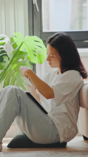 Vista Vertical Morena Chica Asiática Tomando Cuaderno Desde Sofá Mujer — Vídeo de stock