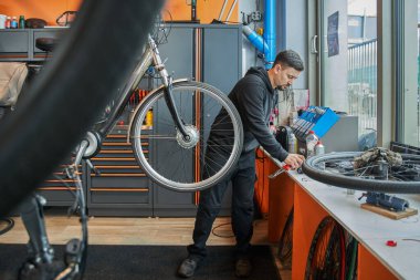 Bisiklet tamircisinin bisiklet tamir takımlarının tam boy görüntüsü. İşine karışan ciddi bir adam. Stok fotoğrafı