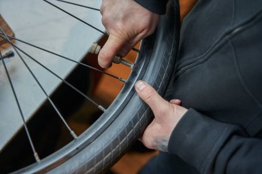 Bisiklet tamircisinde çalışan erkek tamircinin görüntüsü. Özel aletlerle bisikleti tamir eden bilinmeyen bir adam. Meslek kavramı