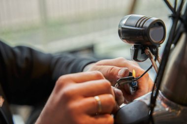 Bisiklet tamir atölyesinde çalışan erkek tamirci elleri. Özel aletlerle bisikleti tamir eden bilinmeyen bir adam. Meslek kavramı